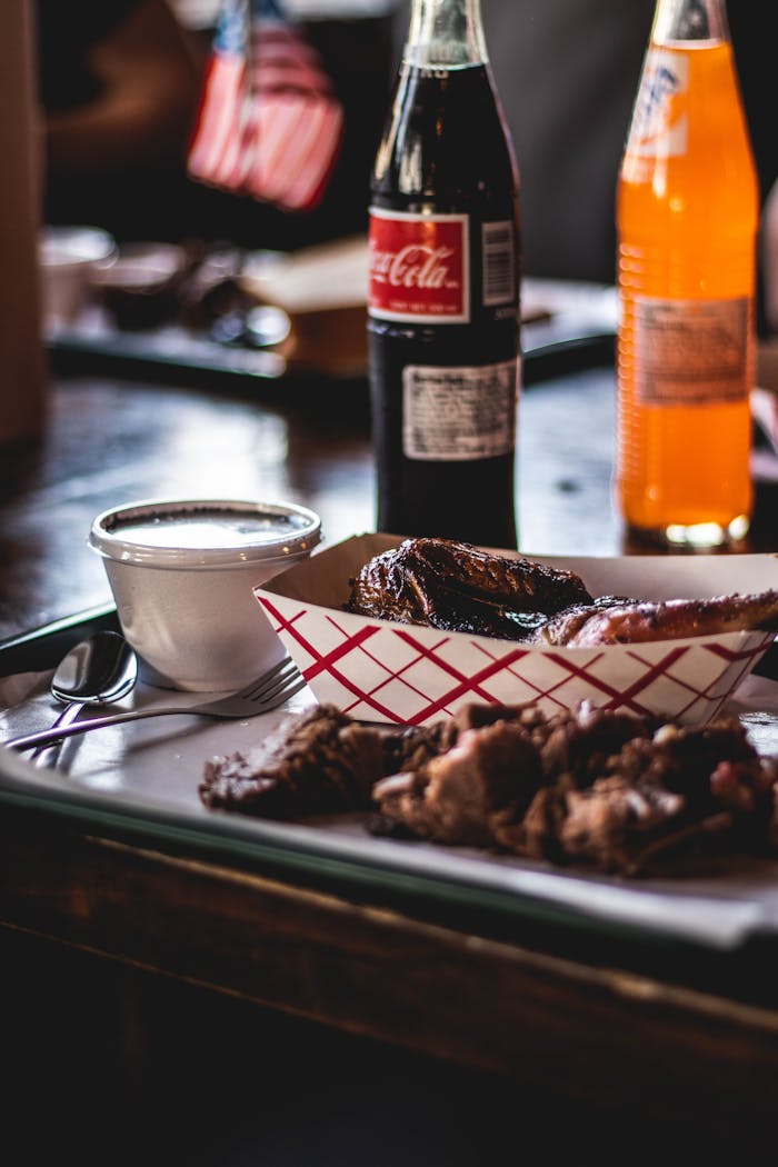 Delicious Texas barbecue served with classic soda and orange drink, perfect for a hearty meal.